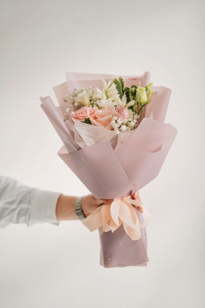 Offerings Elegant pink floral bouquet featuring diverse flowers, beautifully wrapped and presented on a minimal background.