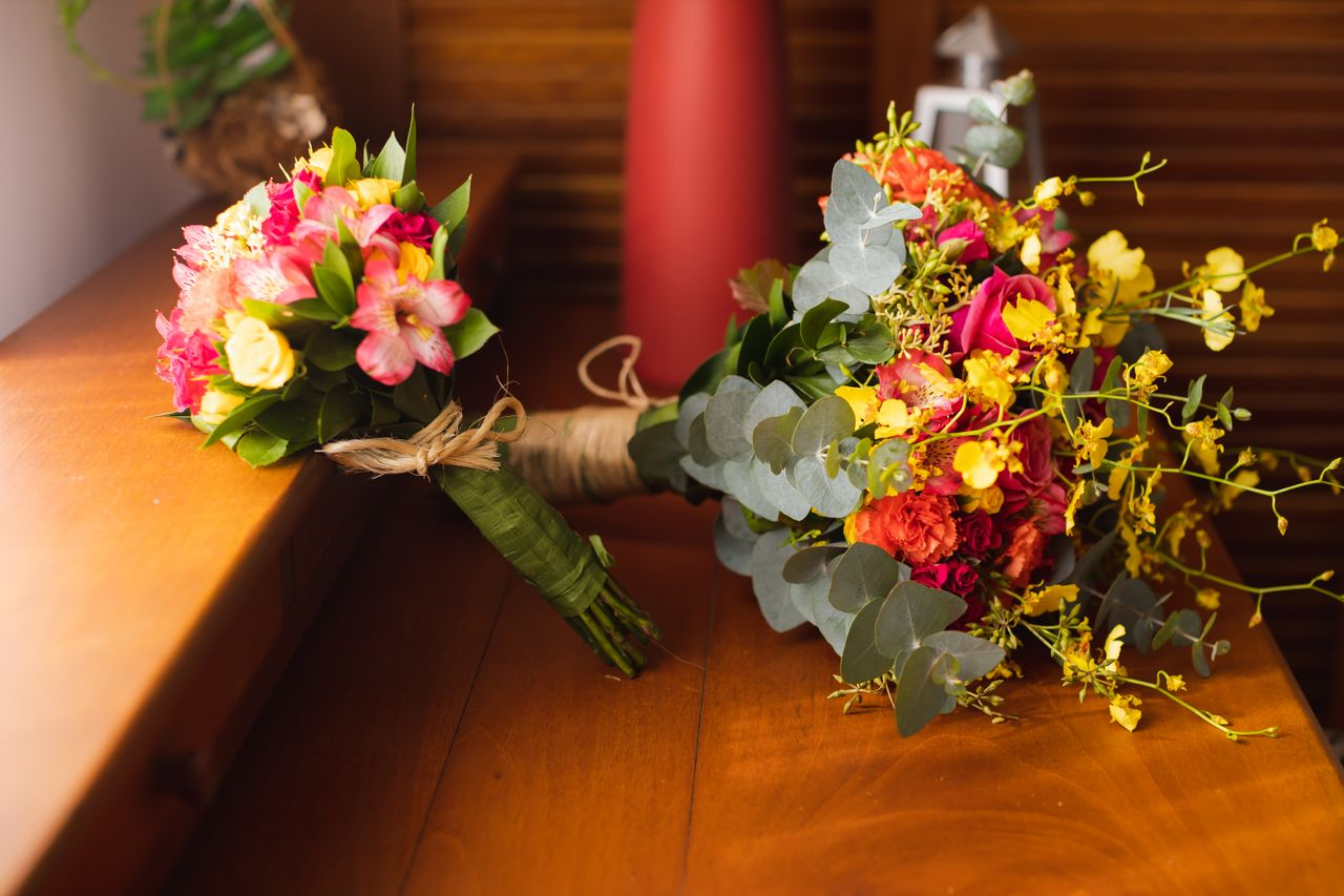 About Two vibrant flower bouquets with mixed flowers displayed on a wooden surface, ideal for weddings or celebrations.
